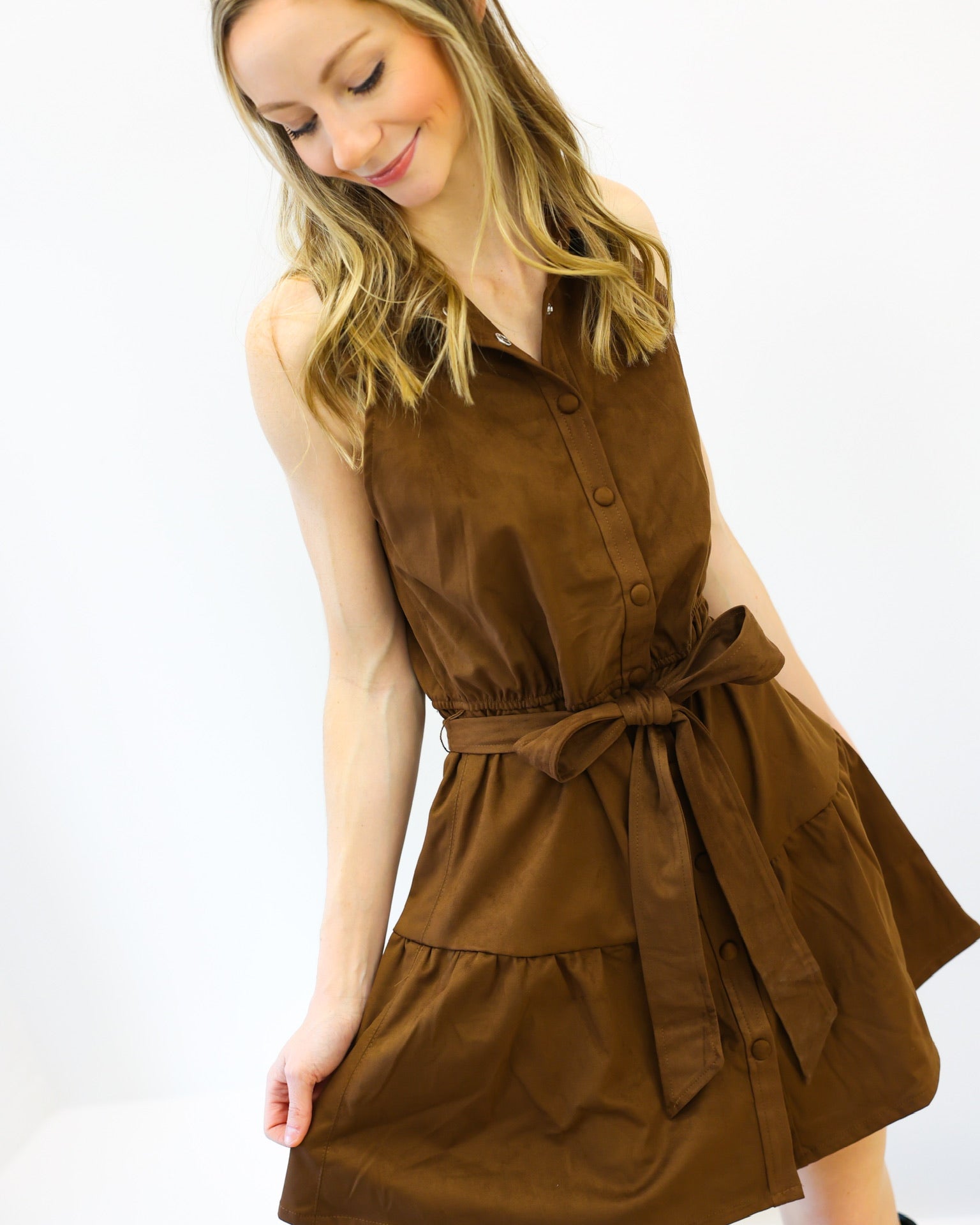 Woman wearing a brown dress with a belt on a white background