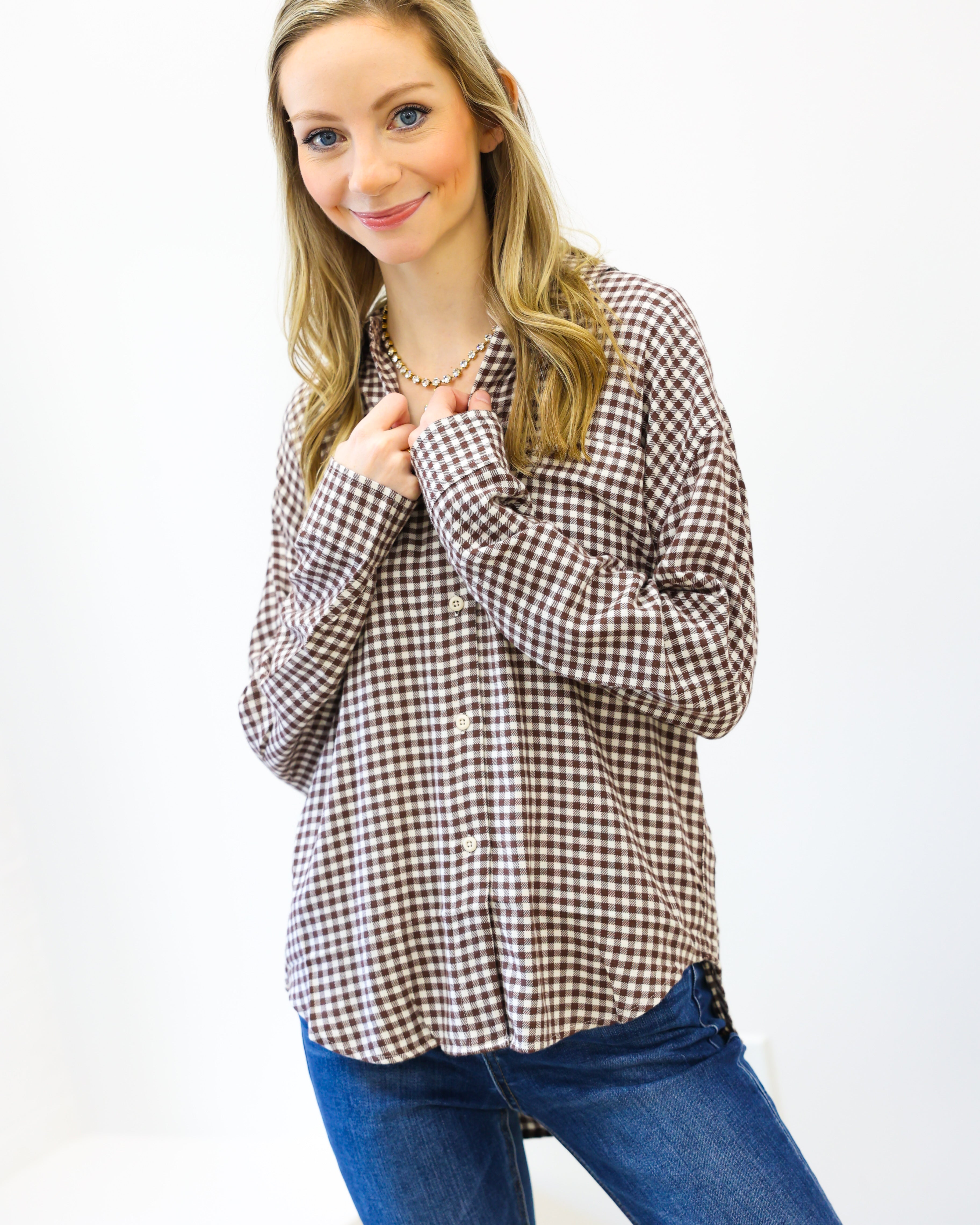 Woman wearing a checkered shirt and blue jeans on a white background