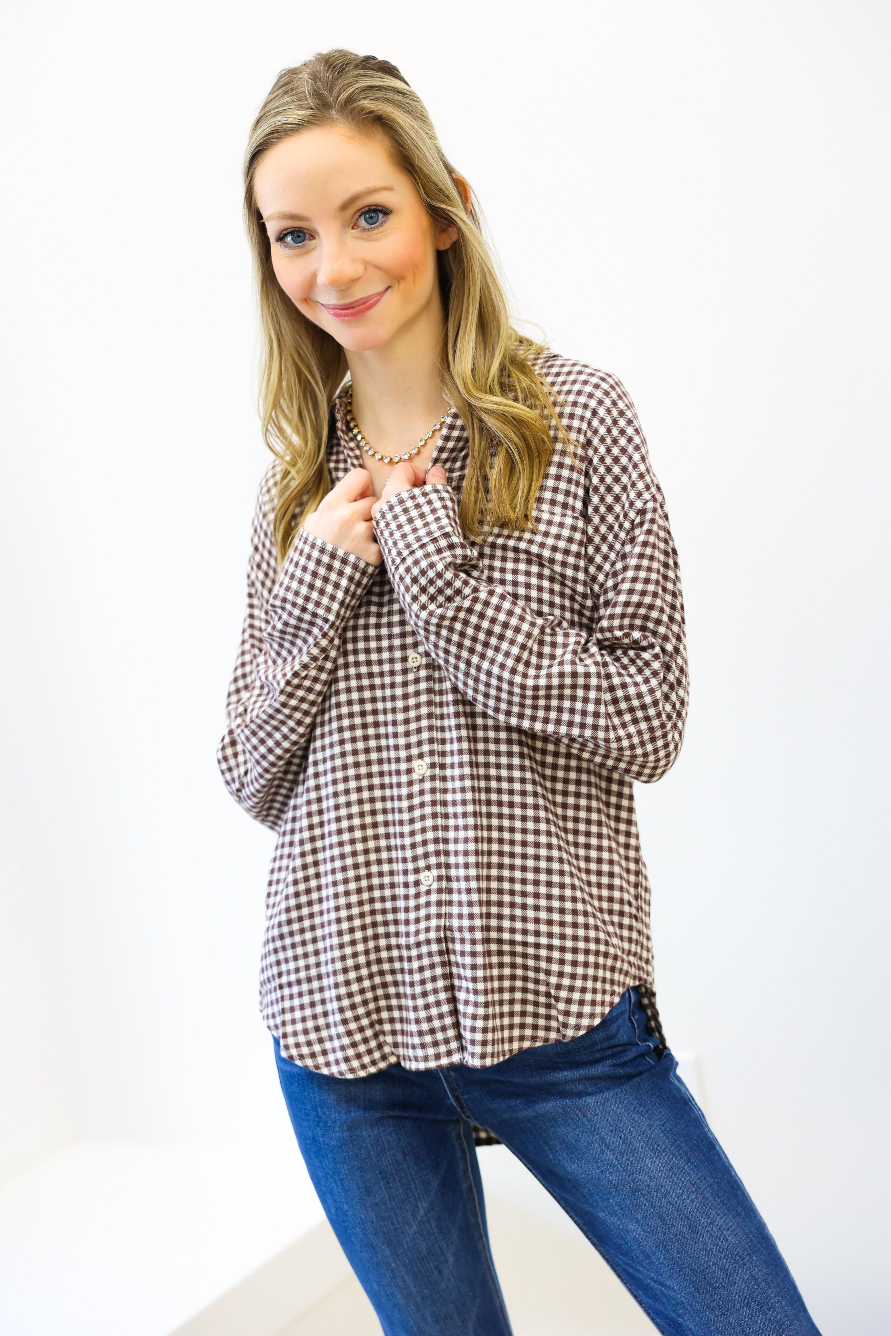Woman wearing a checkered shirt and blue jeans on a white background