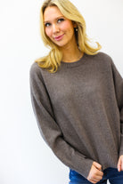 Woman wearing a brown sweater against a white background