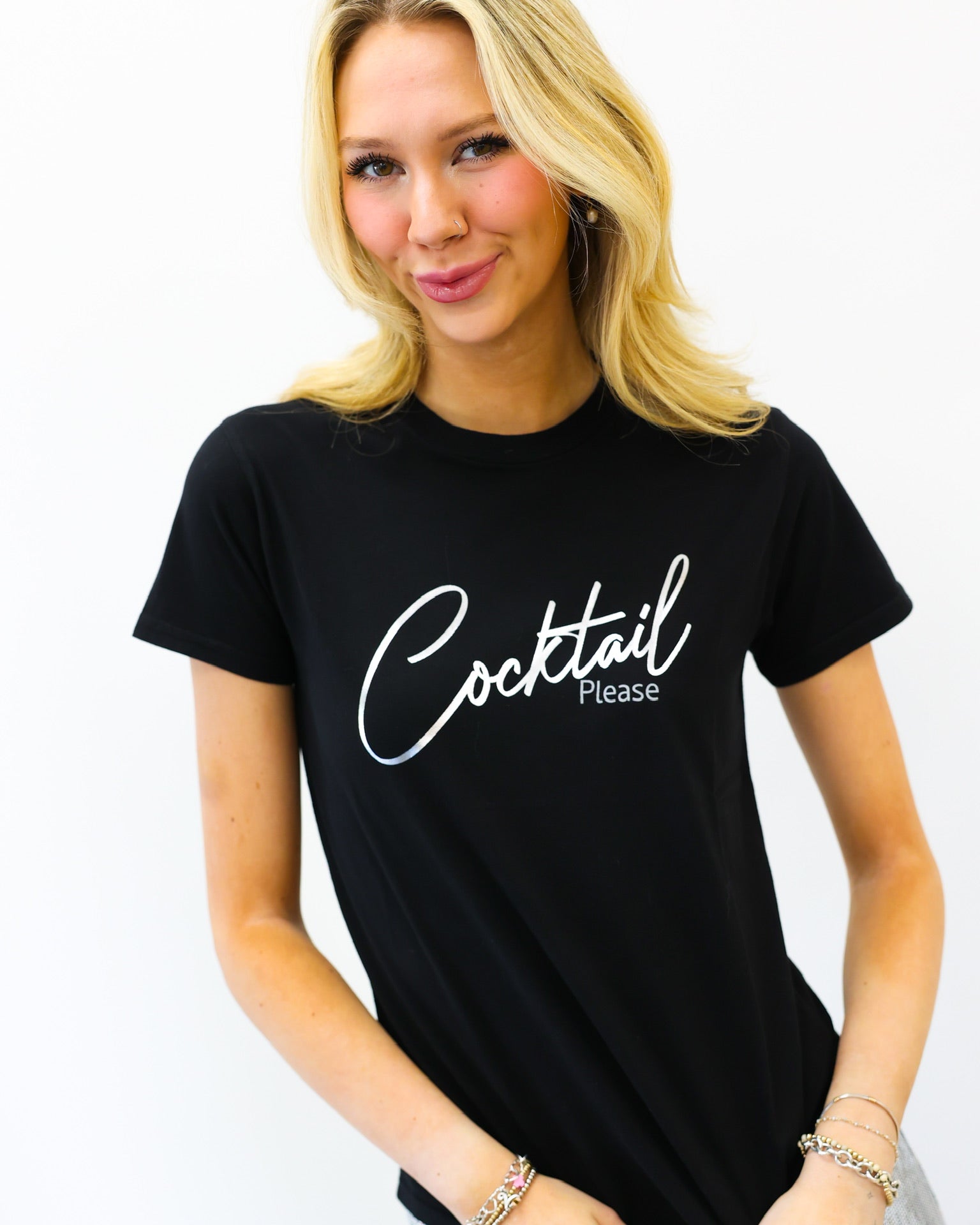 Woman wearing a black t-shirt with 'Cocktail Please' text on a white background