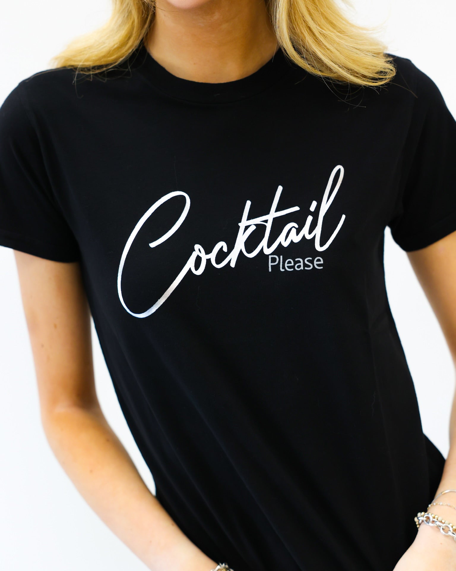 Person wearing a black t-shirt with 'Cocktail Please' text on a white background