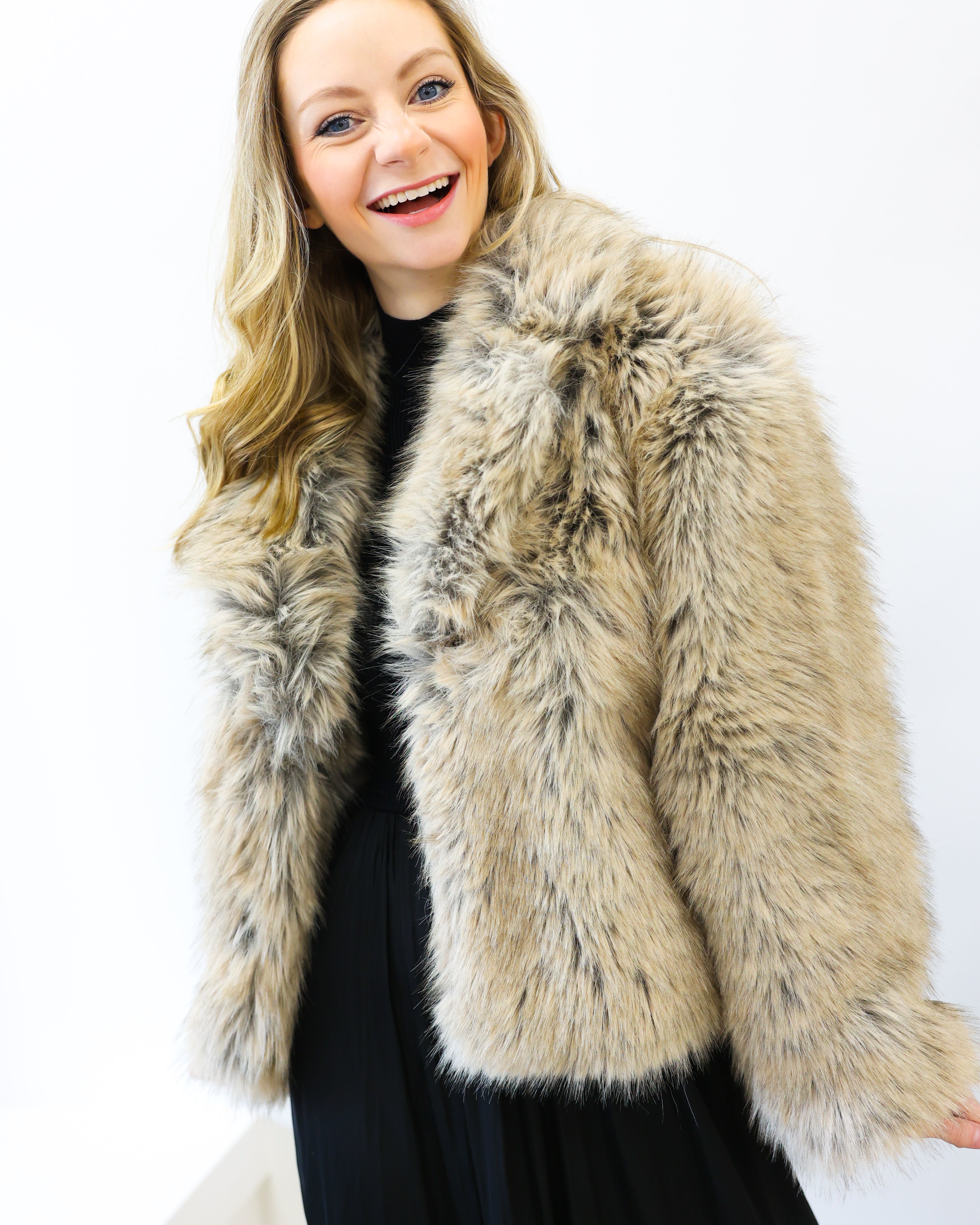 Woman wearing a fur vest against a white background