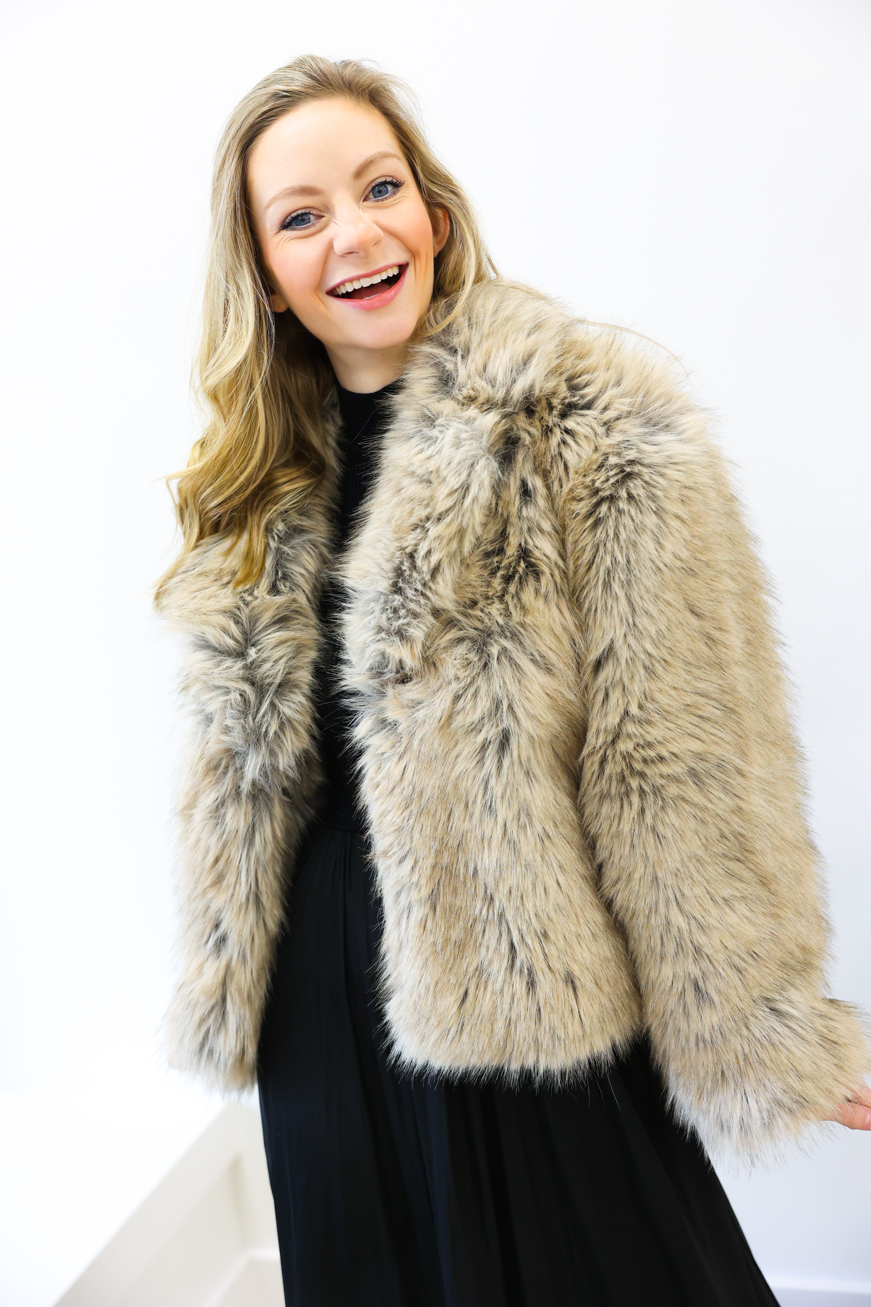Woman wearing a fur vest against a white background