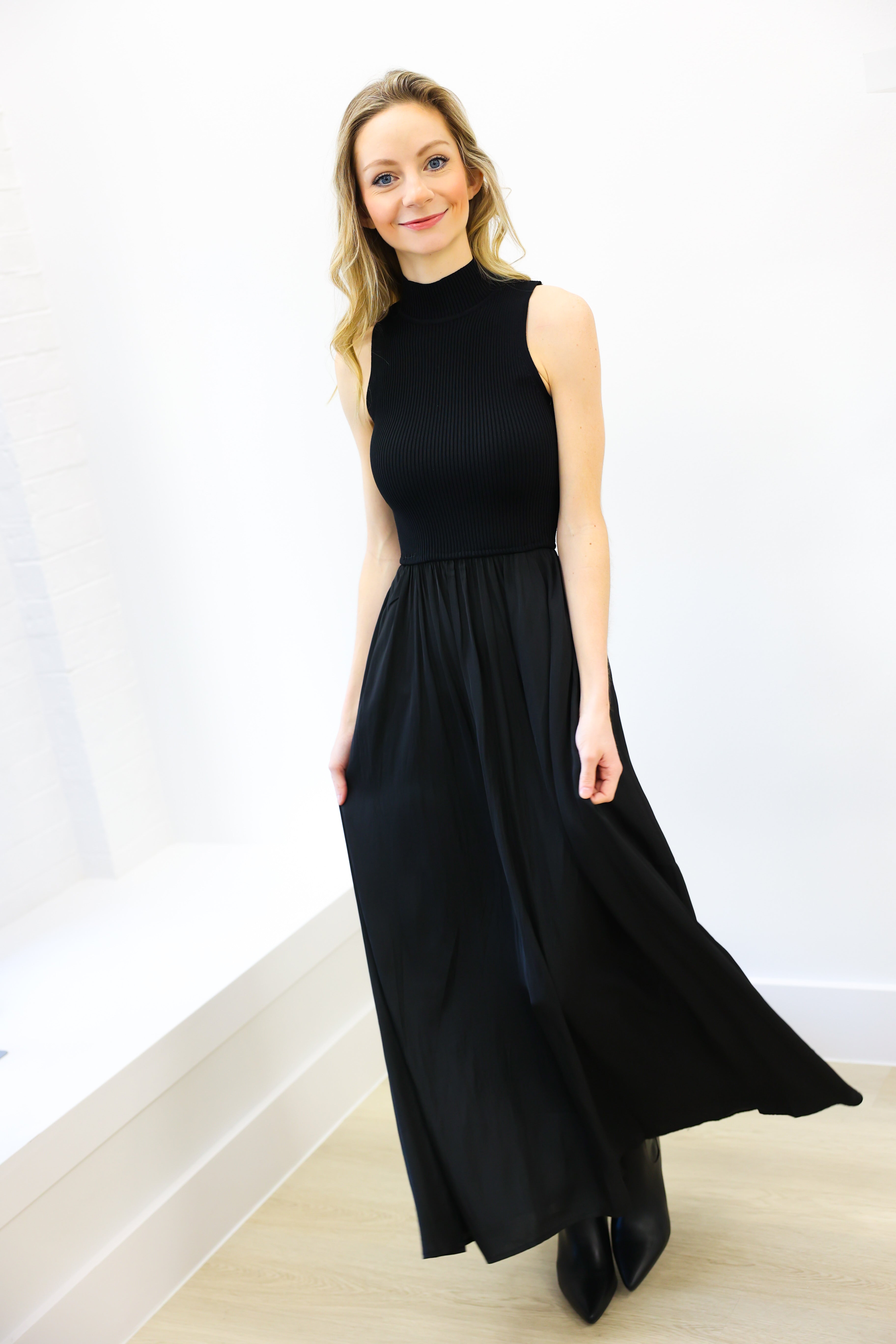 Woman wearing a black sleeveless dress against a white background