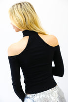 Woman wearing a black off-shoulder top with a white background