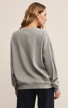 Woman wearing a gray sweater on a beige background
