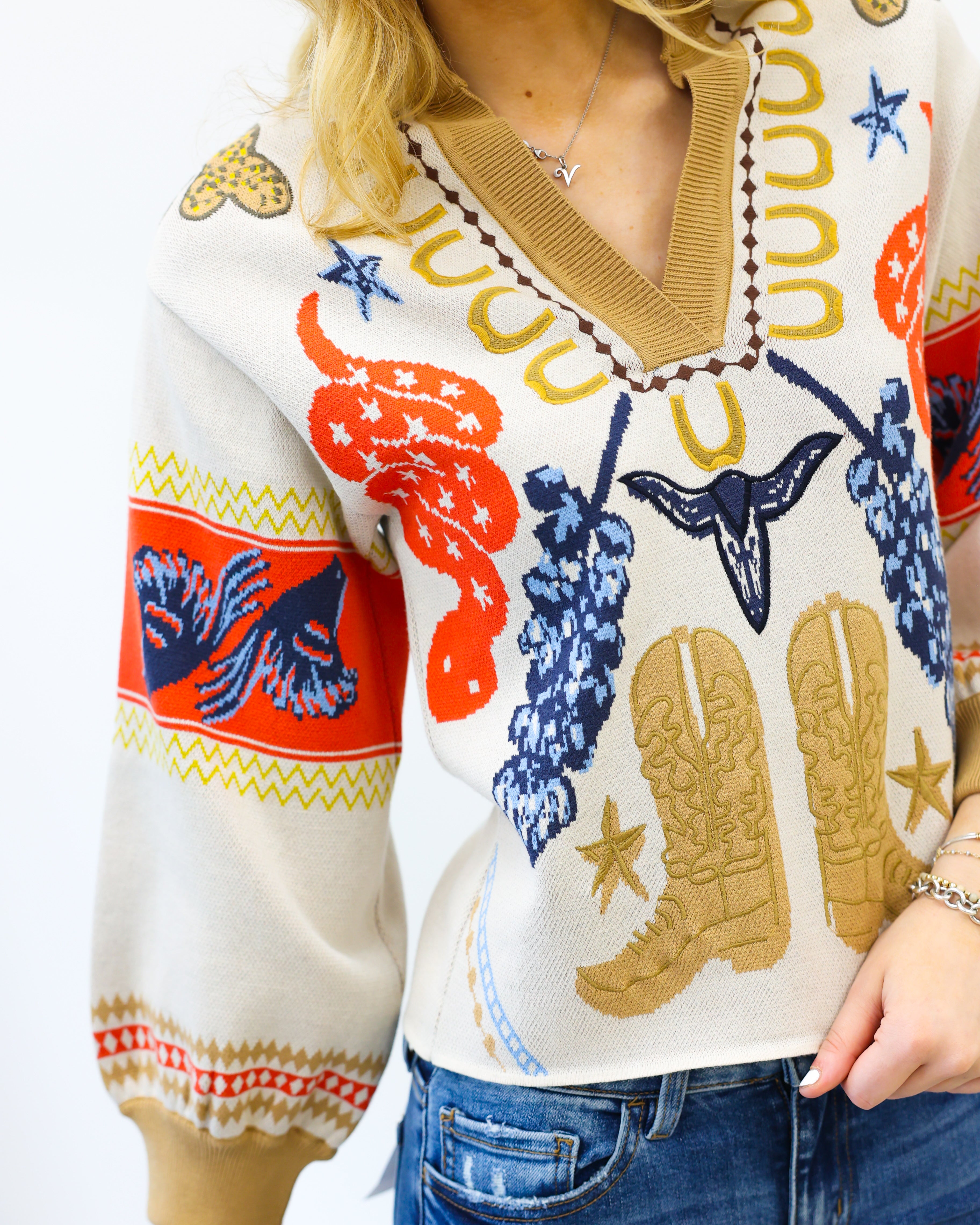 Person wearing a colorful sweater with cowboy boot and star designs on a white background