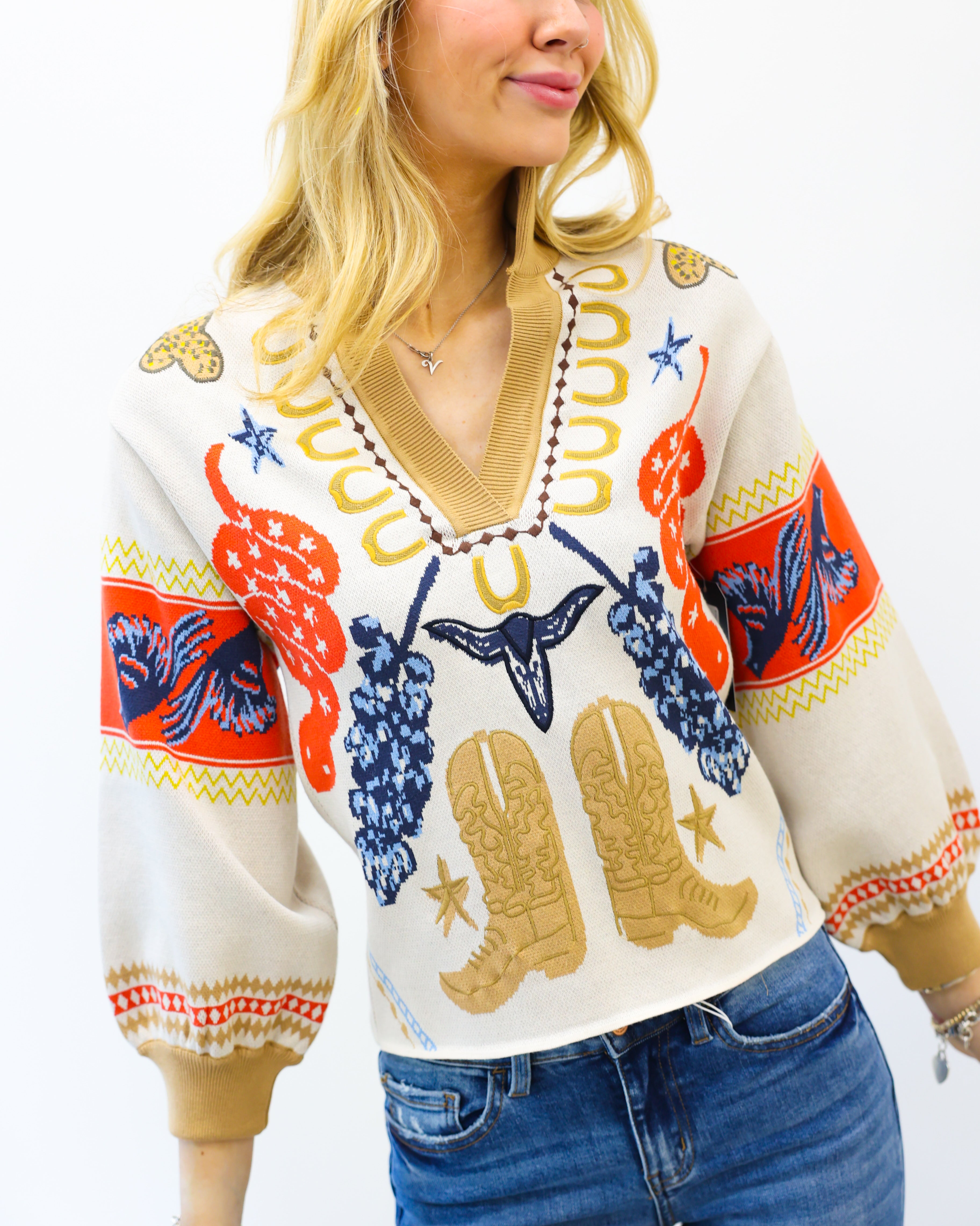 Woman wearing a colorful patterned sweater with cowboy boots and grapes on a white background