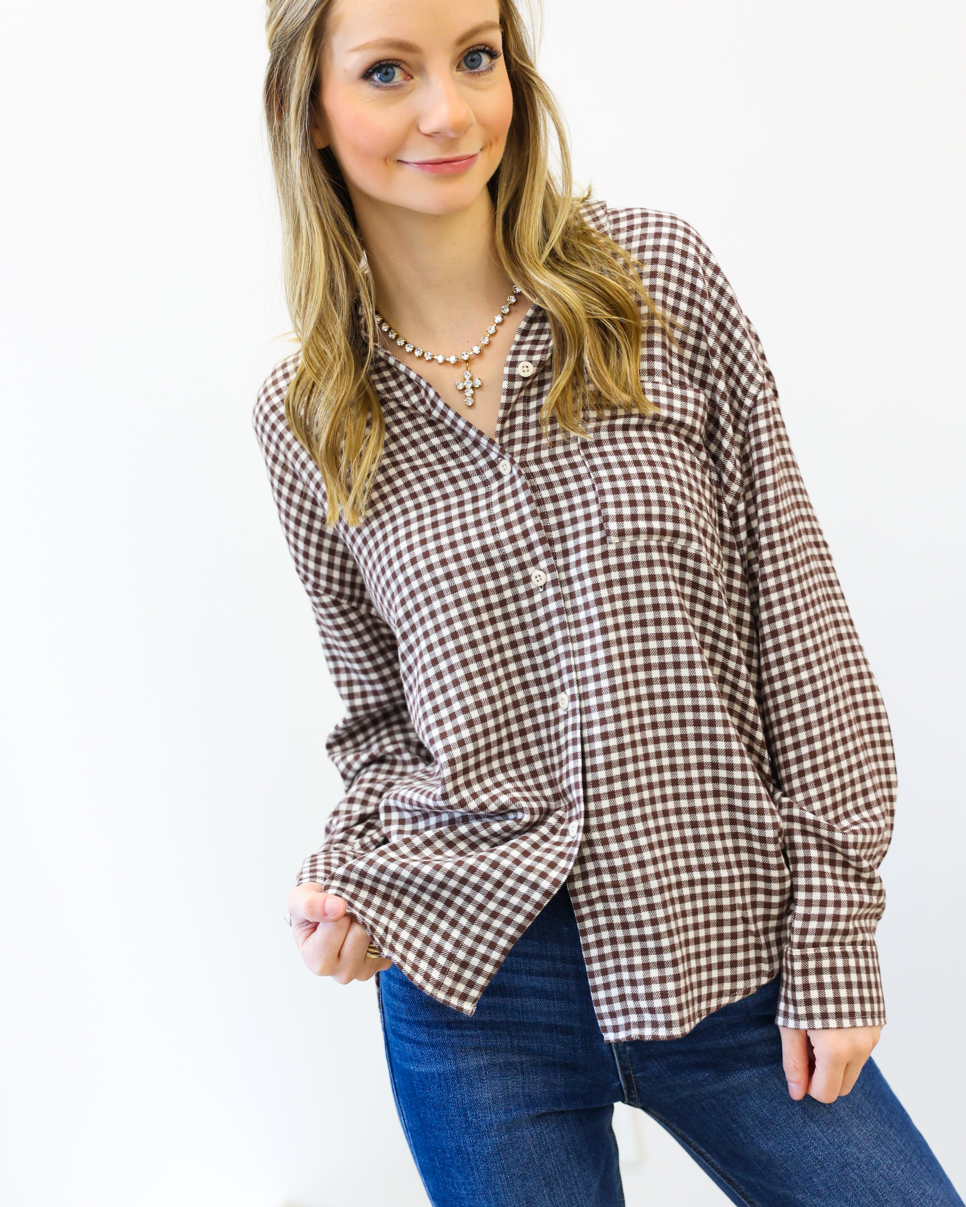 Woman wearing a plaid shirt and blue jeans on a white background