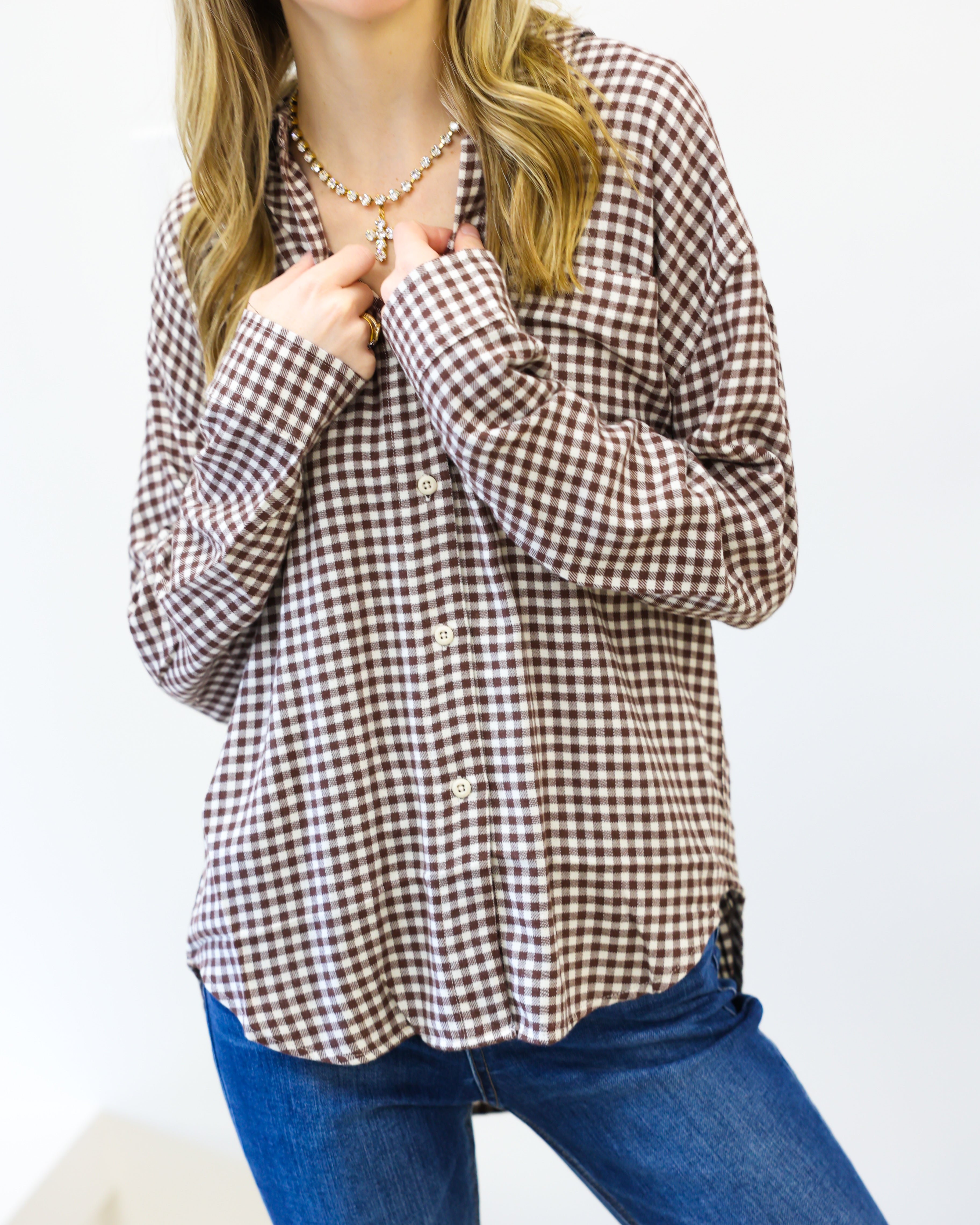 Woman wearing a checkered shirt and blue jeans on a white background