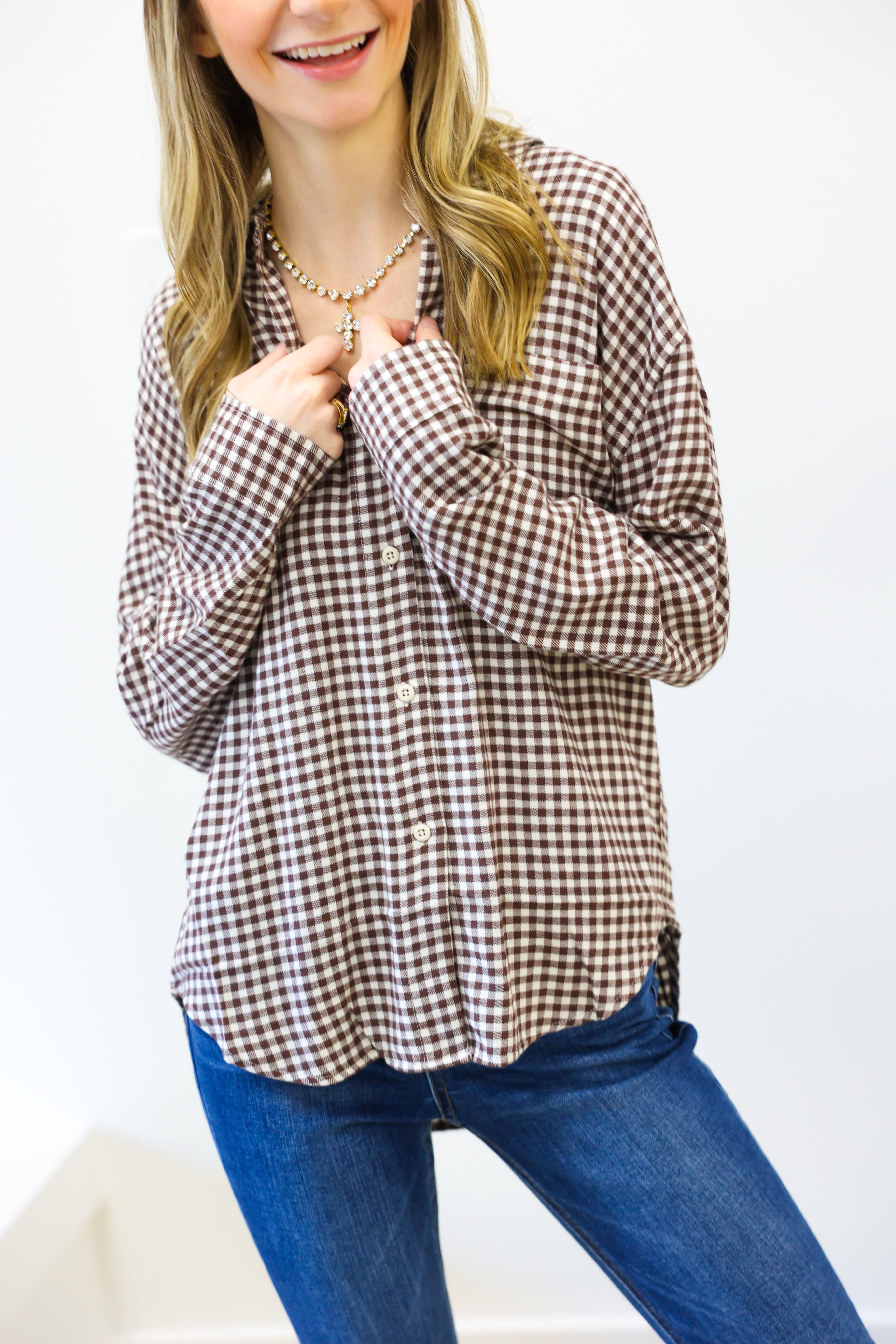 Woman wearing a checkered shirt and blue jeans on a white background
