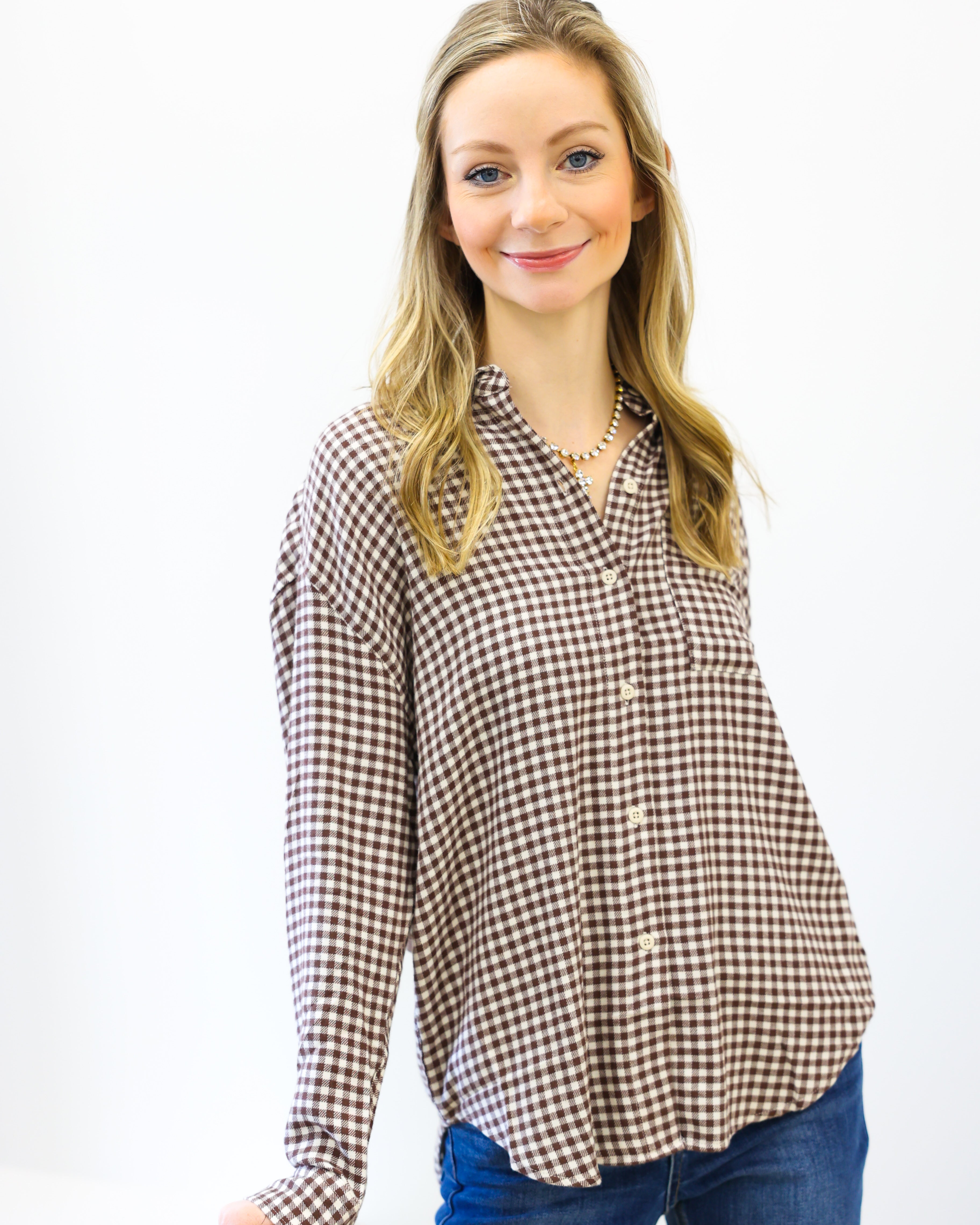 Woman wearing a checkered shirt and jeans on a white background