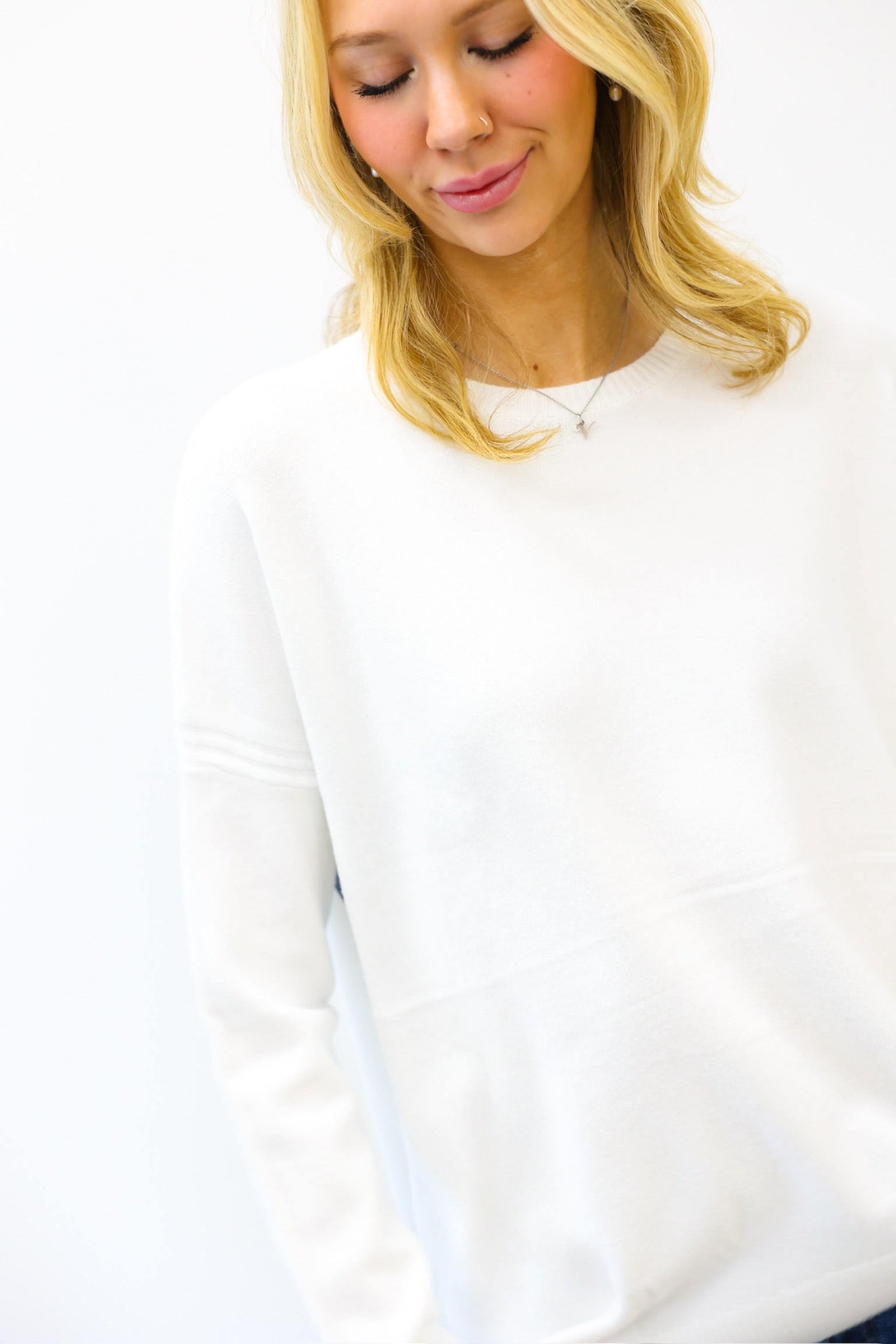 Woman wearing a white long-sleeve shirt on a white background