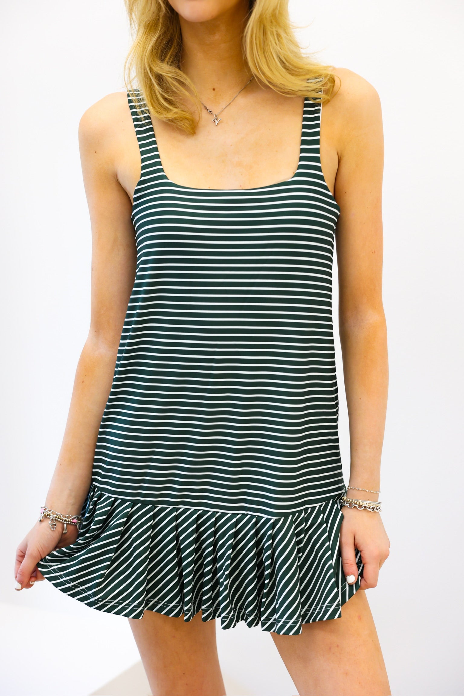 Woman wearing a green and white striped dress with a plain background