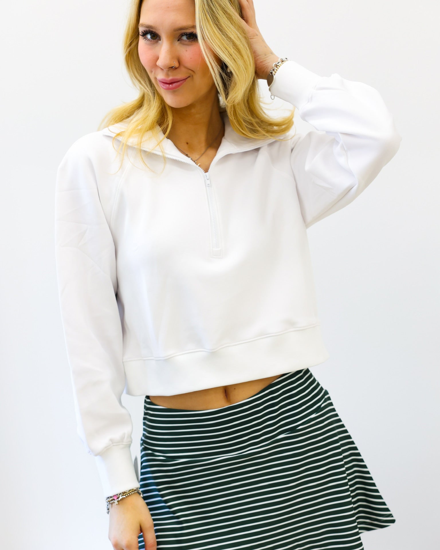 Woman wearing a white blouse and striped skirt against a white background