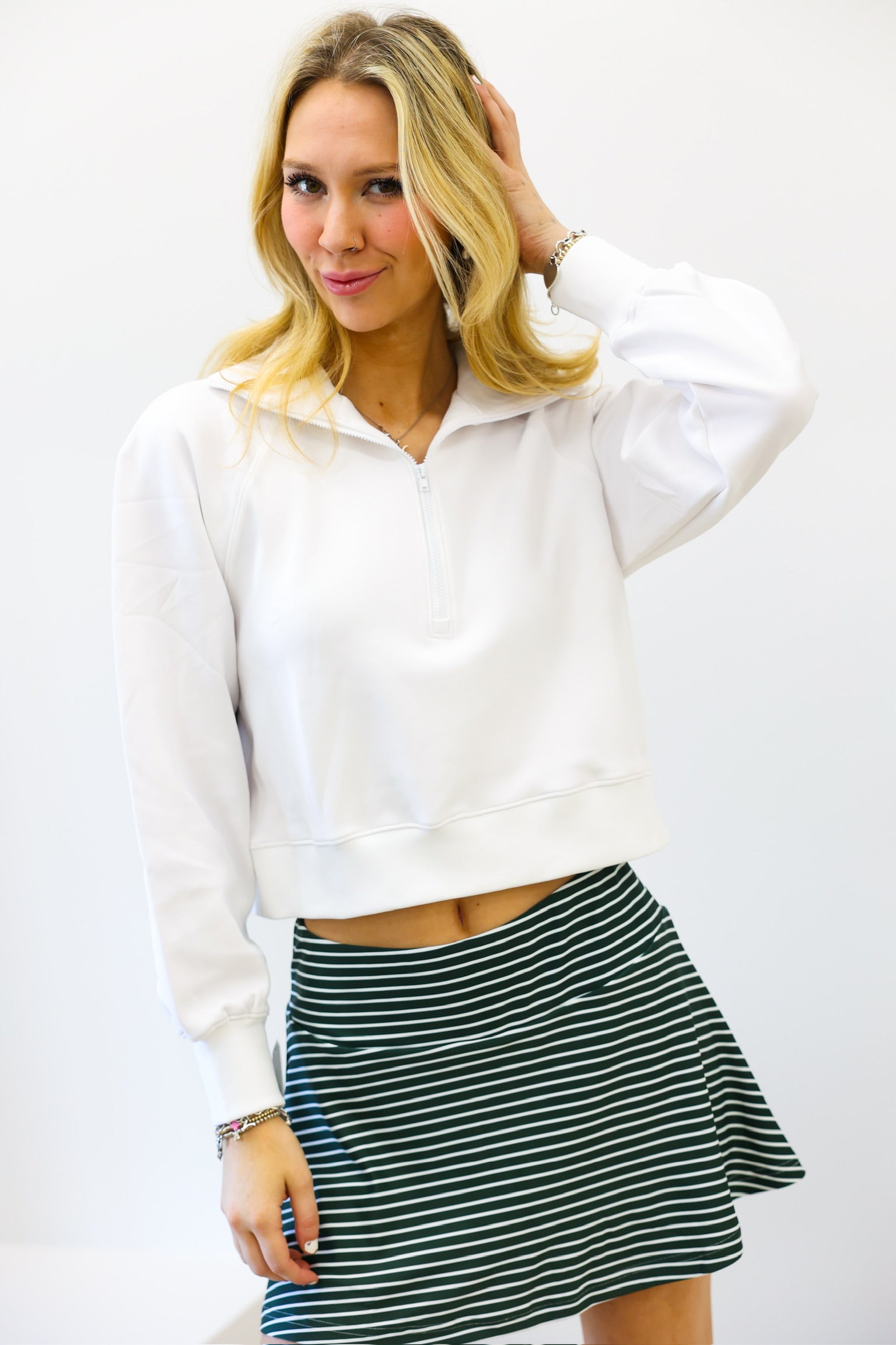 Woman wearing a white blouse and striped skirt against a white background
