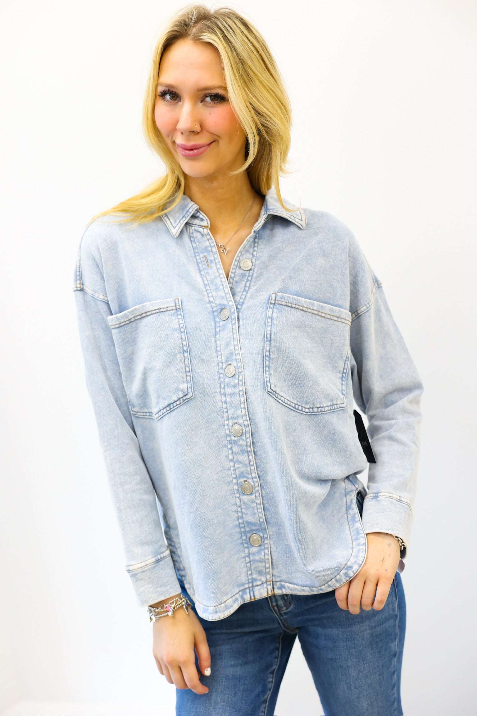 Woman wearing a light blue denim shirt on a white background