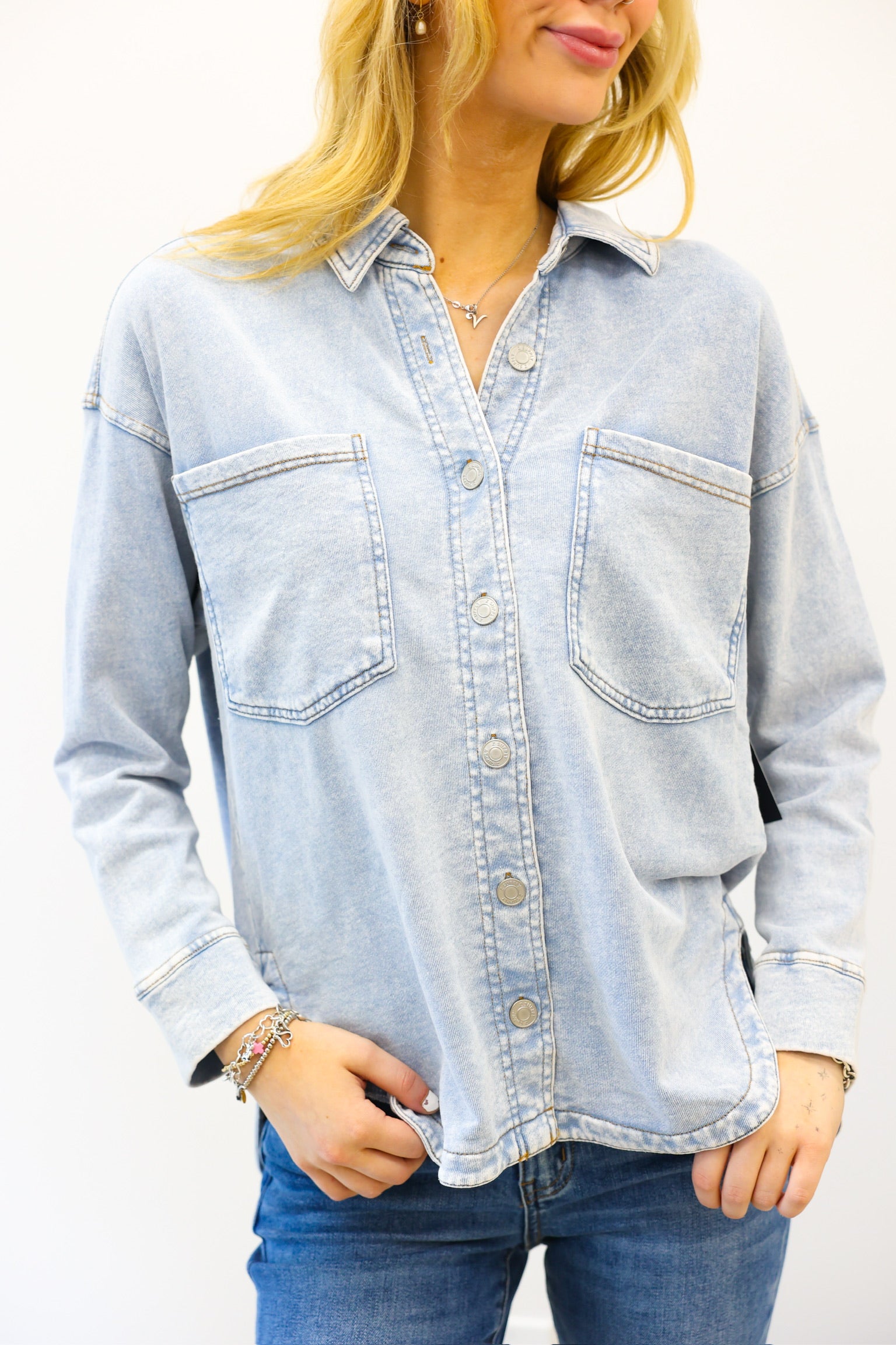 Light blue denim shirt worn by a person on a white background