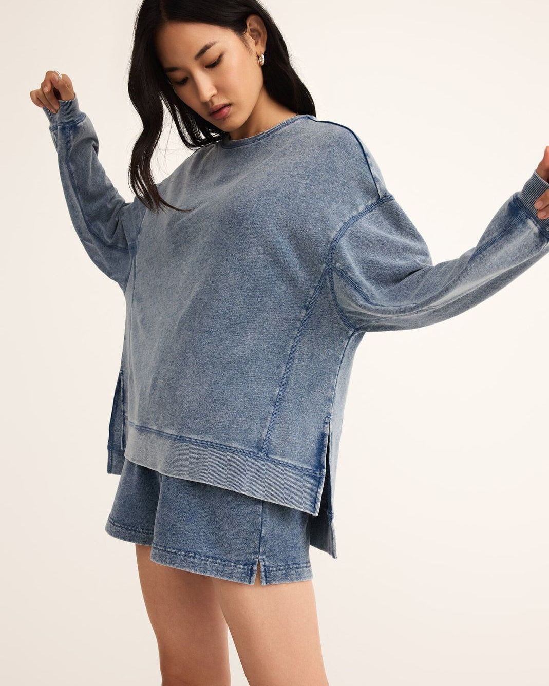 Woman wearing a blue denim outfit on a plain background