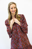 Woman wearing a red floral dress against a white background
