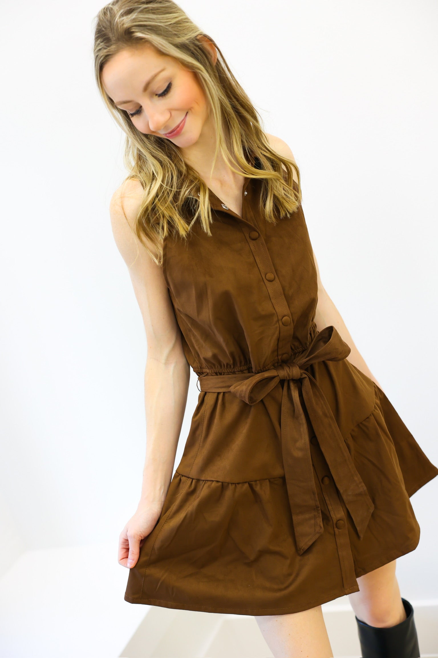 Woman wearing a brown dress with a belt on a white background