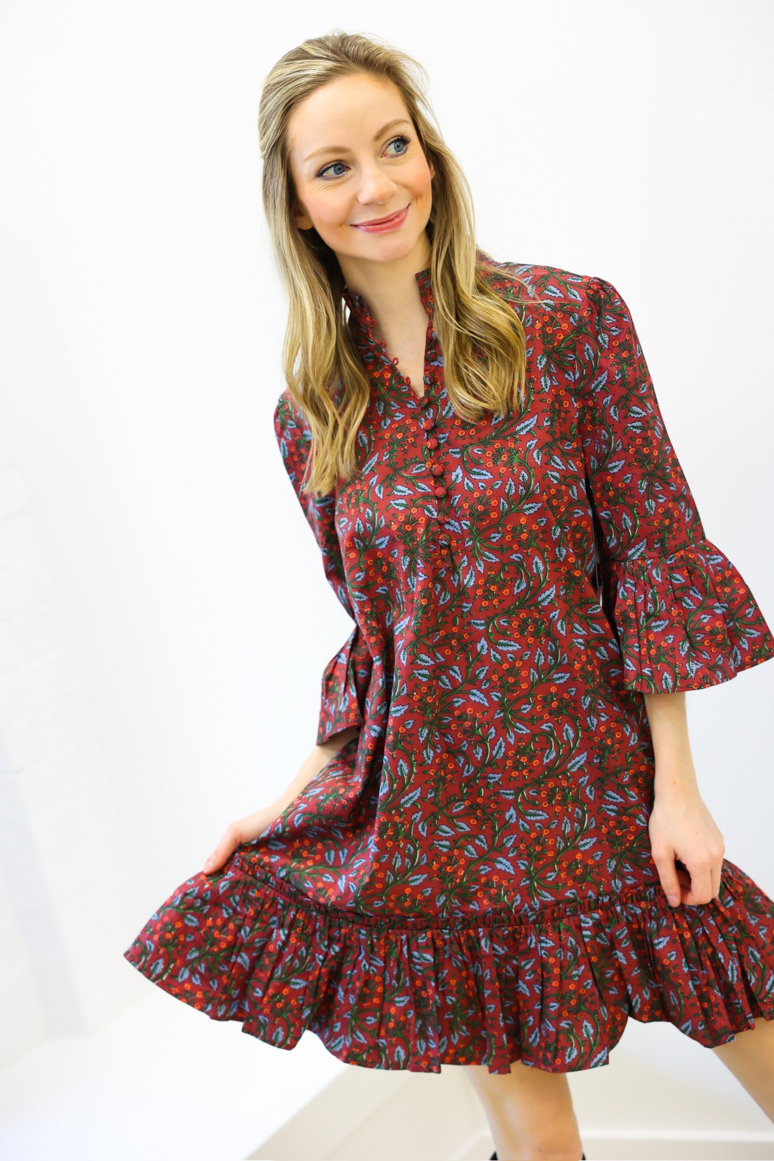 Woman wearing a red floral dress on a white background
