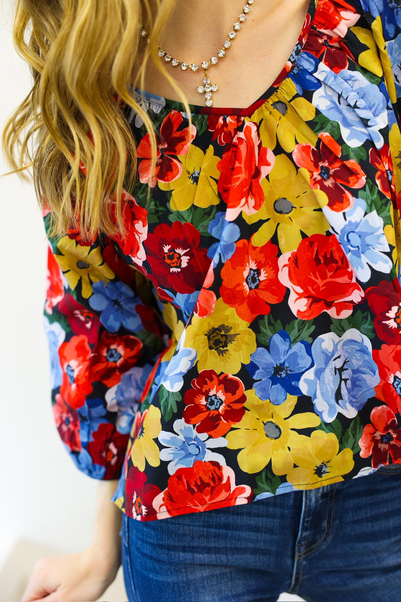 Colorful floral blouse with a person wearing it against a white background