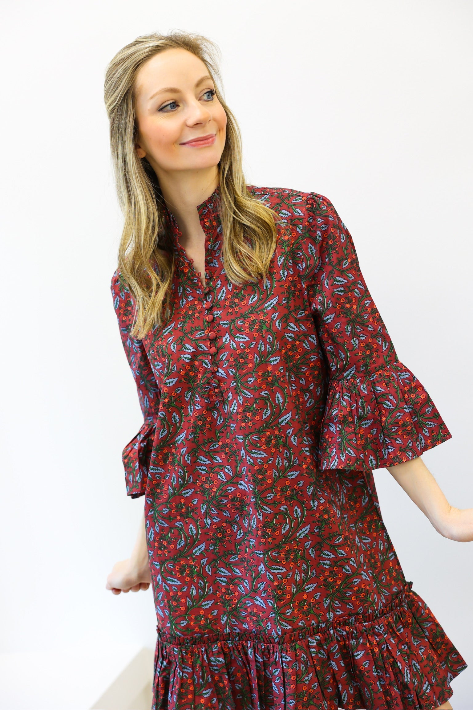 Woman wearing a red floral dress against a white background