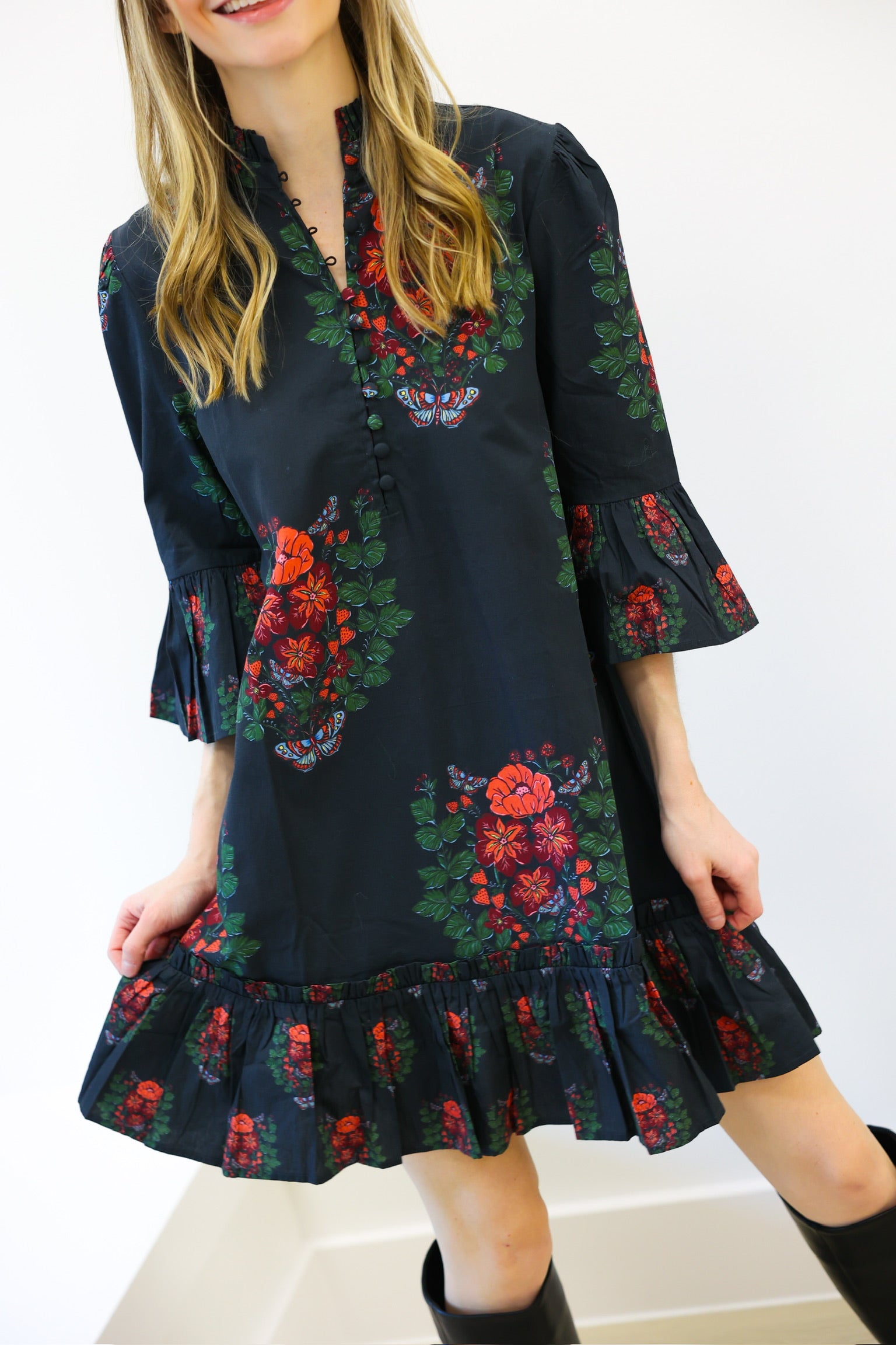 Woman wearing a dark floral dress with a white background