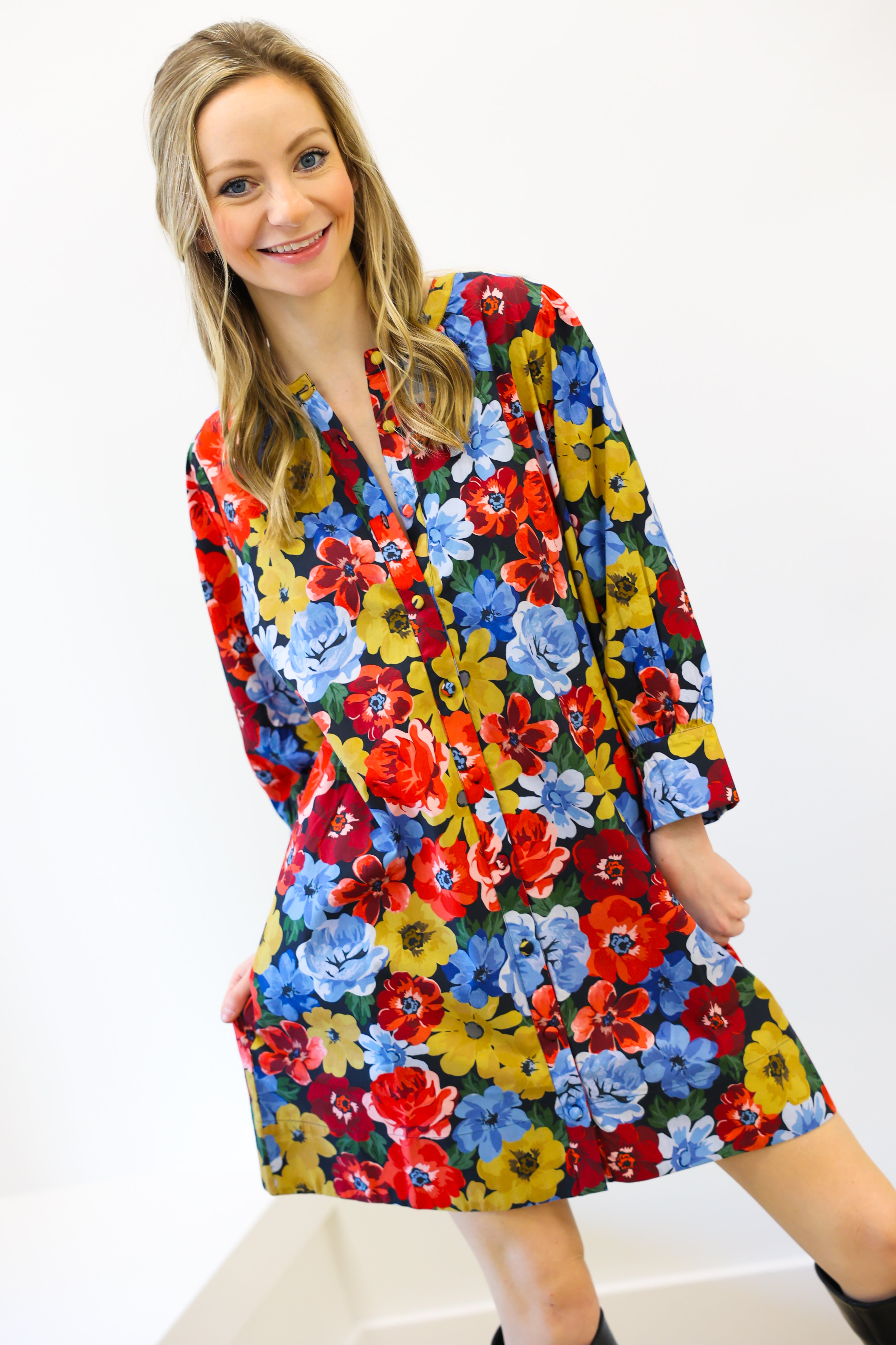 Woman wearing a colorful floral dress against a white background