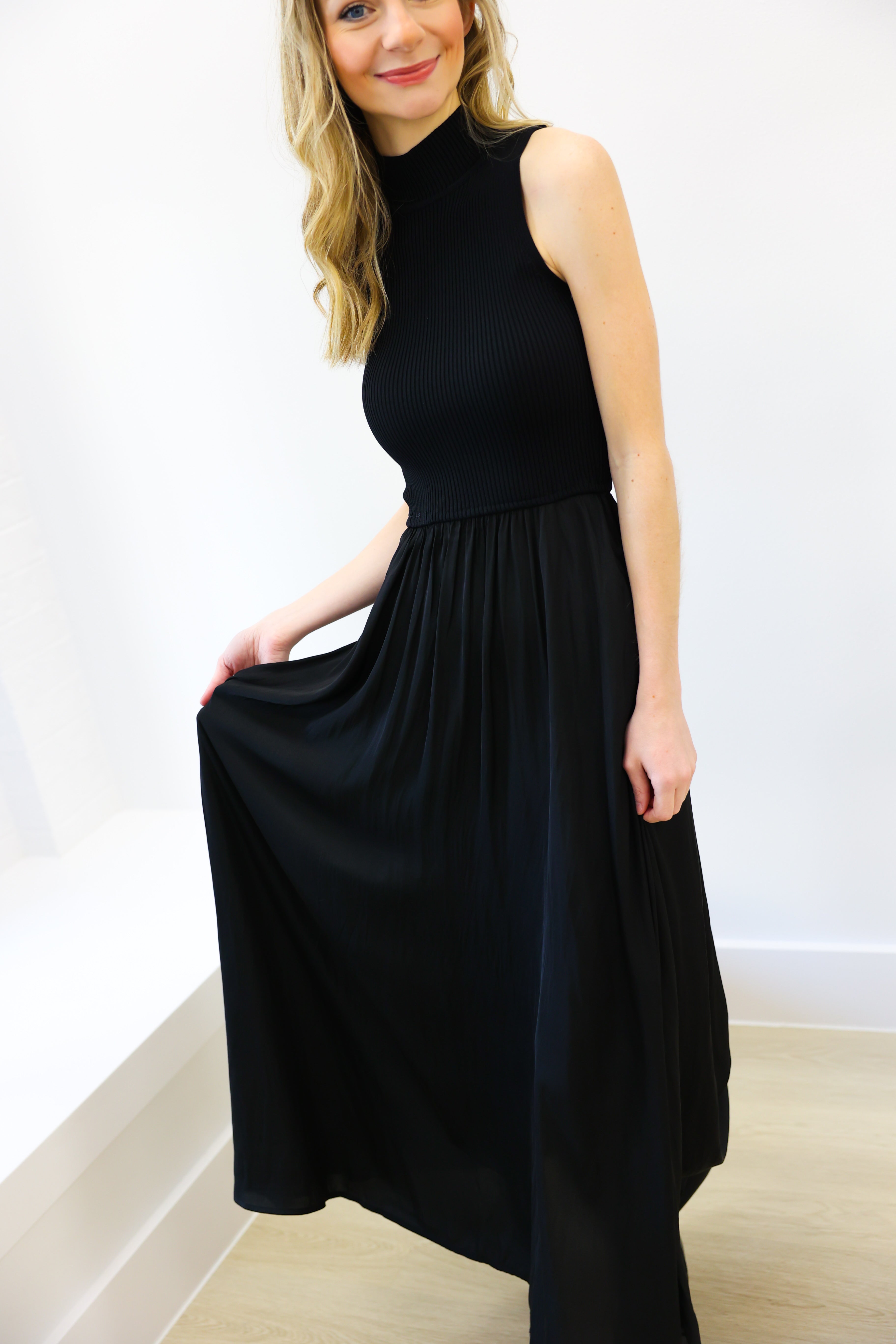 Woman wearing a black sleeveless dress against a white background