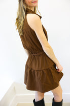 Woman wearing a brown dress with a white background