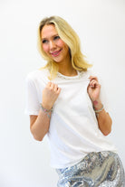 Woman wearing a white t-shirt and silver sequin skirt on a white background