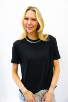 Woman wearing a black t-shirt with a plain background