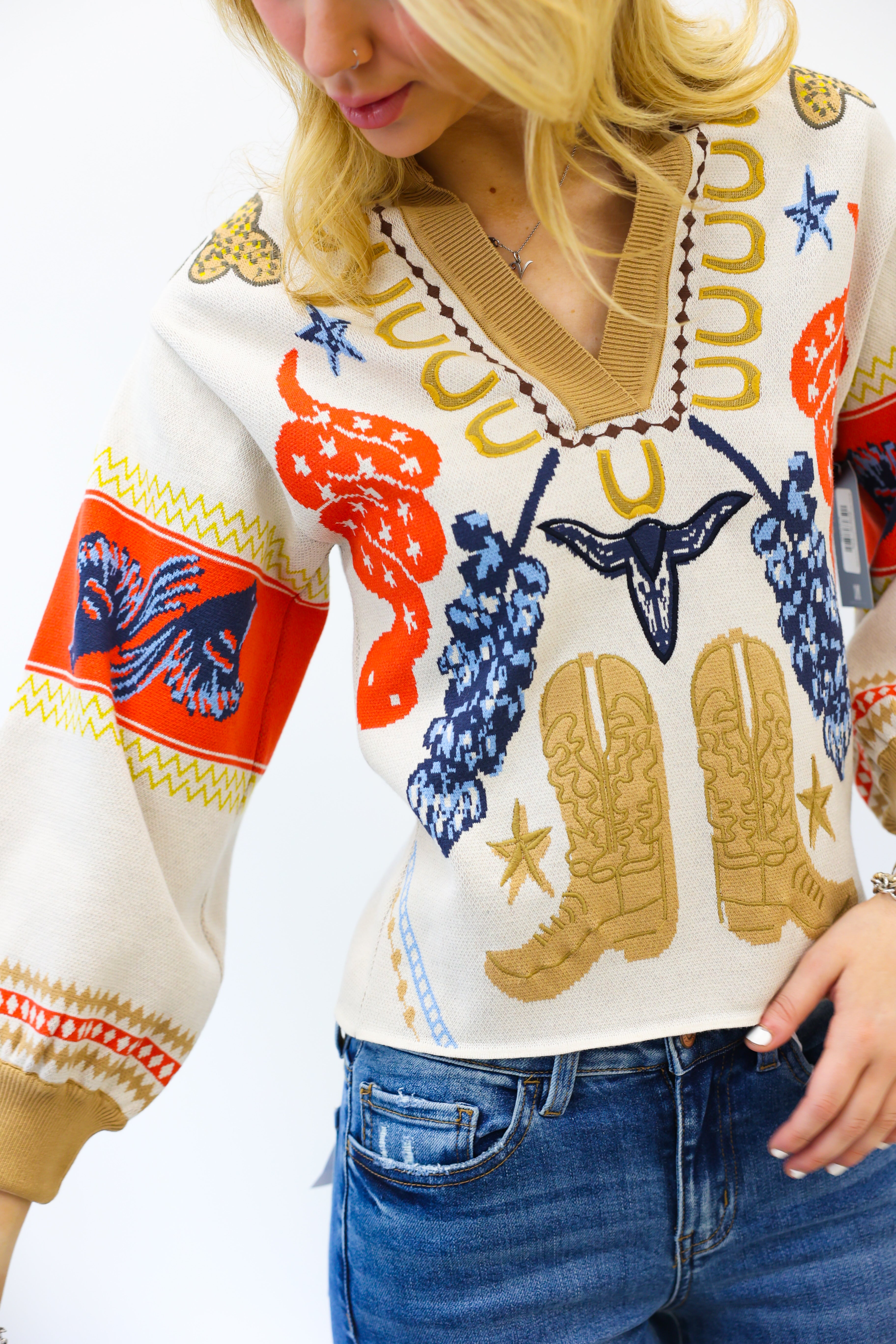Person wearing a colorful sweater with cowboy boot design