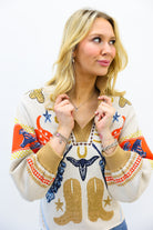 Woman wearing a colorful sweater with cowboy boot design on a white background