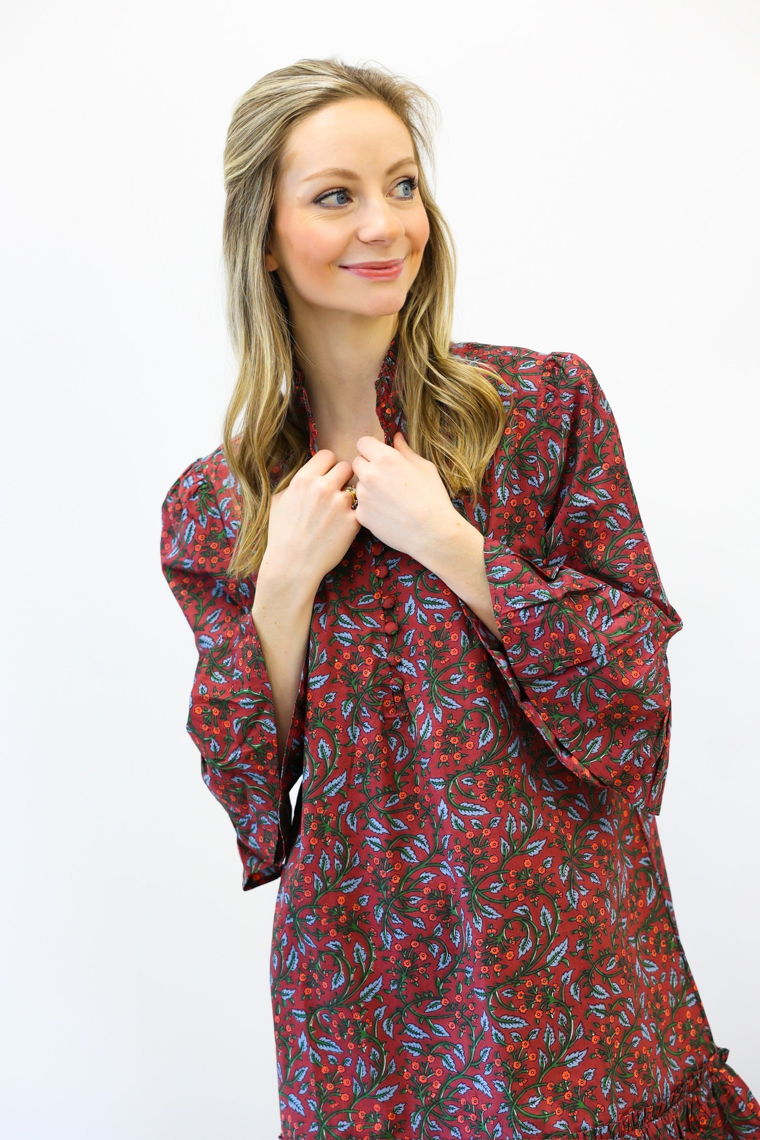 Woman wearing a red floral dress against a white background