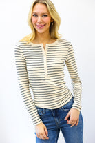 Woman wearing a striped long-sleeve top and jeans on a white background