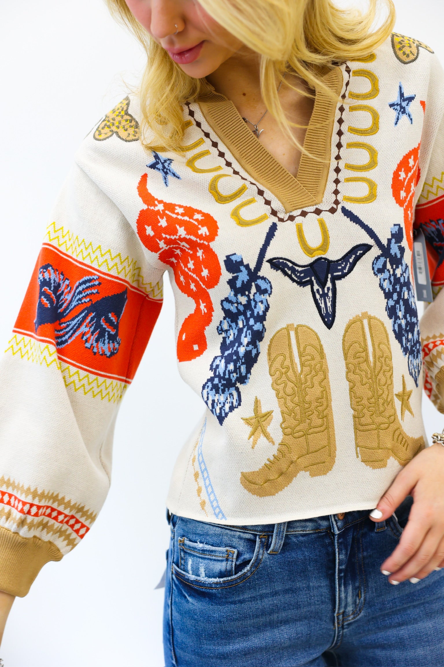 Person wearing a colorful sweater with cowboy boot design