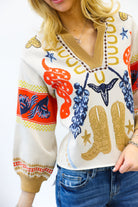 Person wearing a colorful sweater with cowboy boot and star designs on a white background