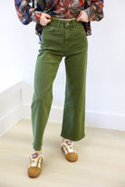 Person wearing green pants and floral shirt with slippers indoors