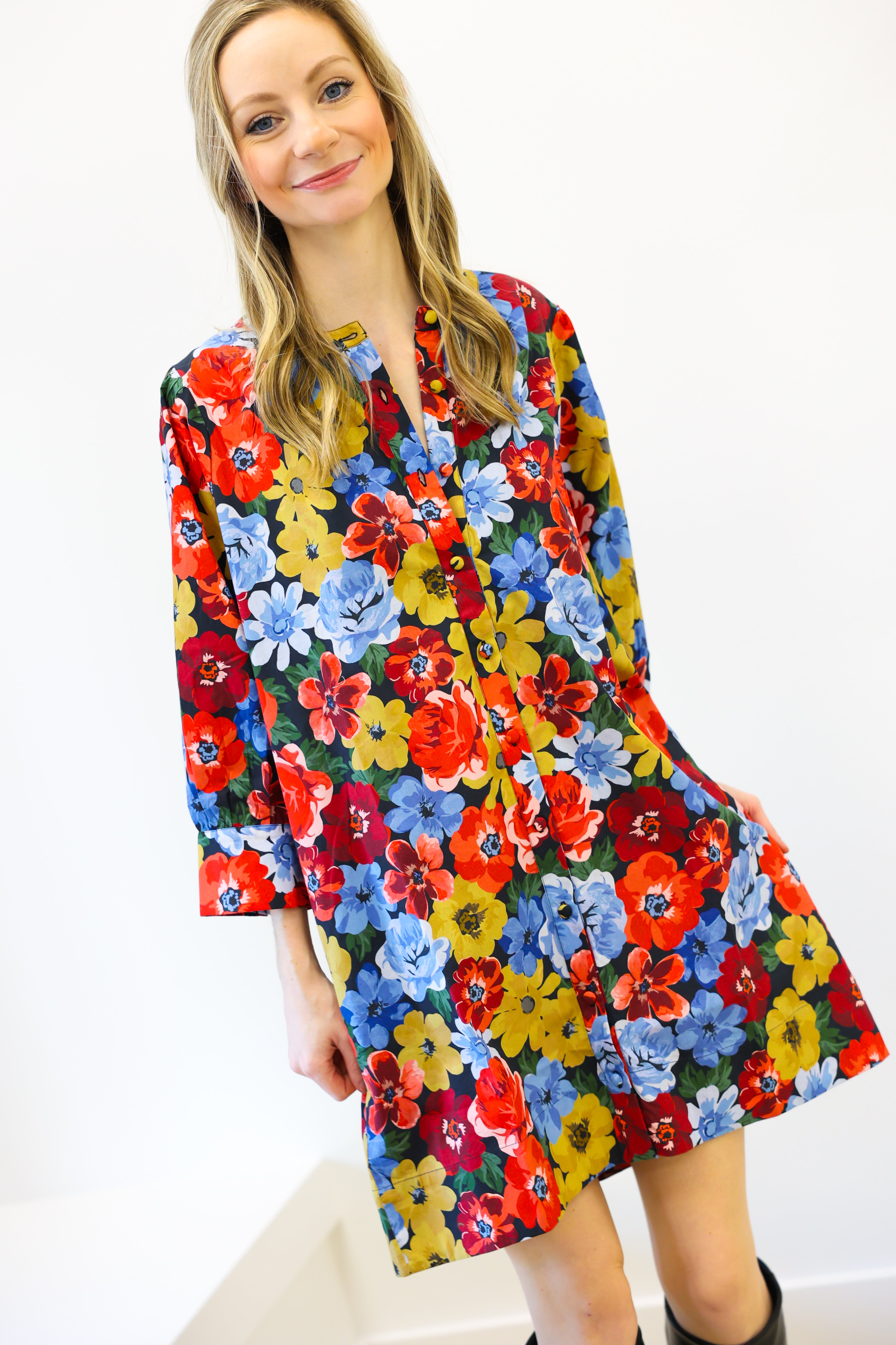 Woman wearing a colorful floral dress against a white background