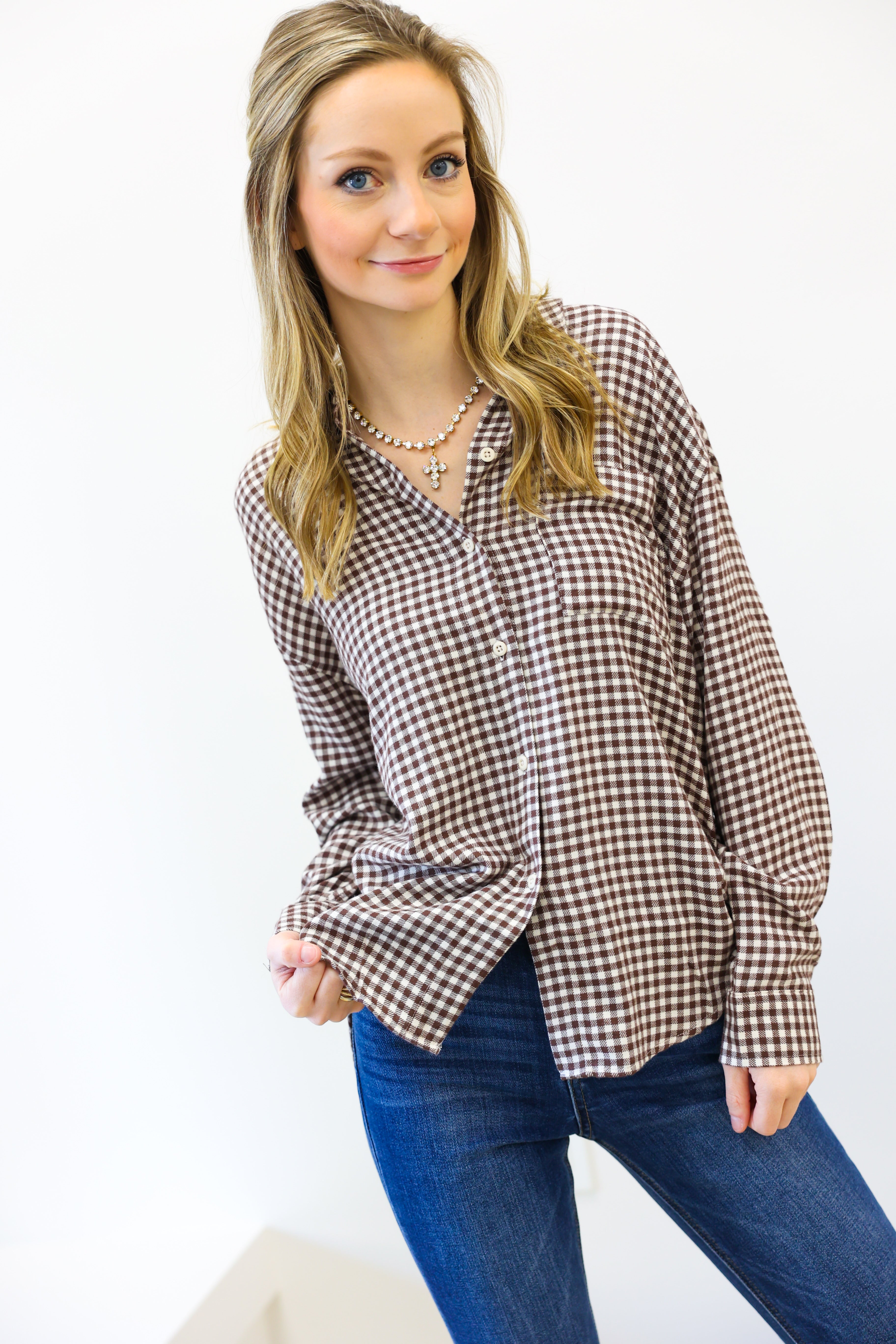 Woman wearing a plaid shirt and blue jeans on a white background