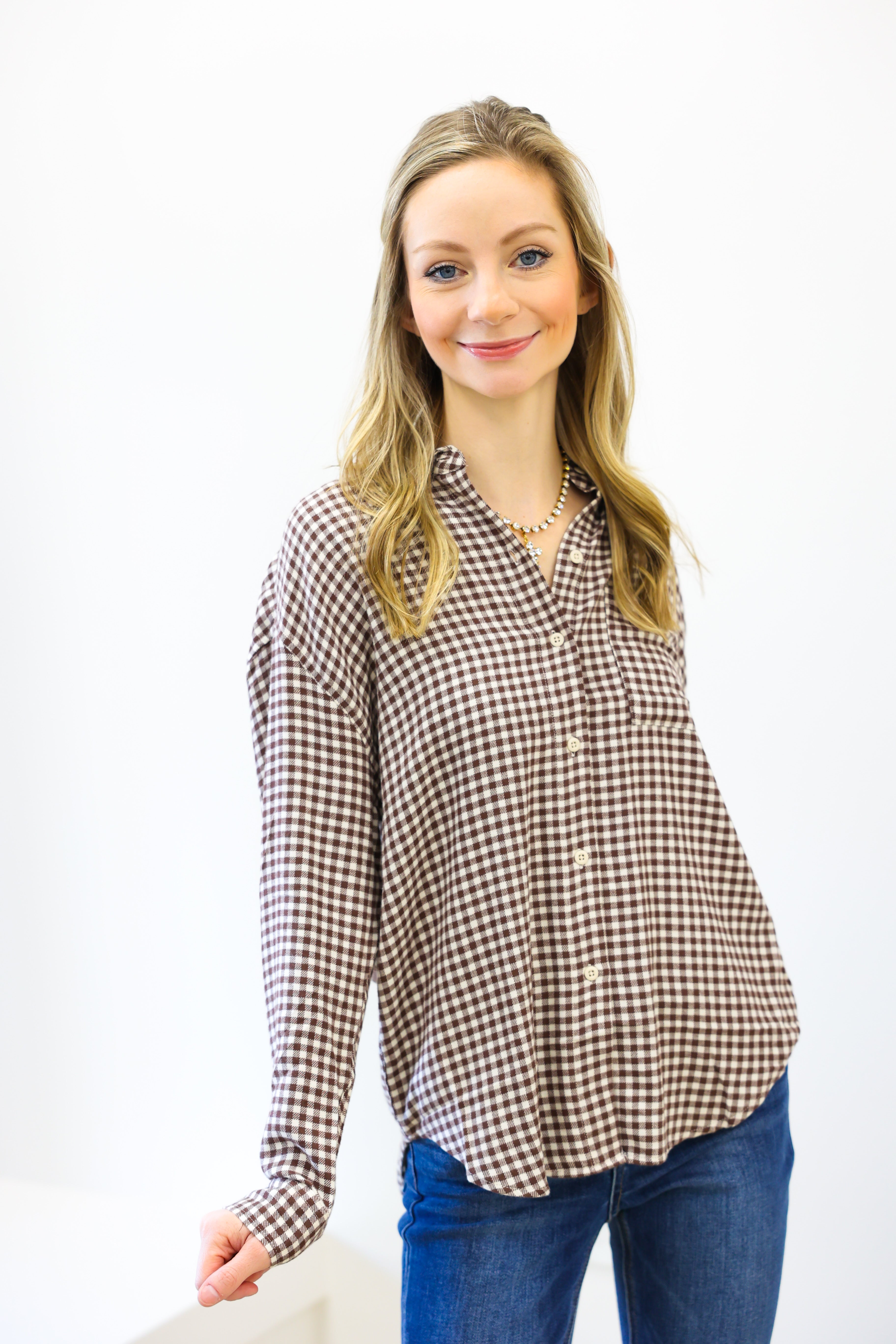 Woman wearing a checkered shirt and jeans on a white background