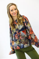 Woman wearing a colorful floral blouse with a white background