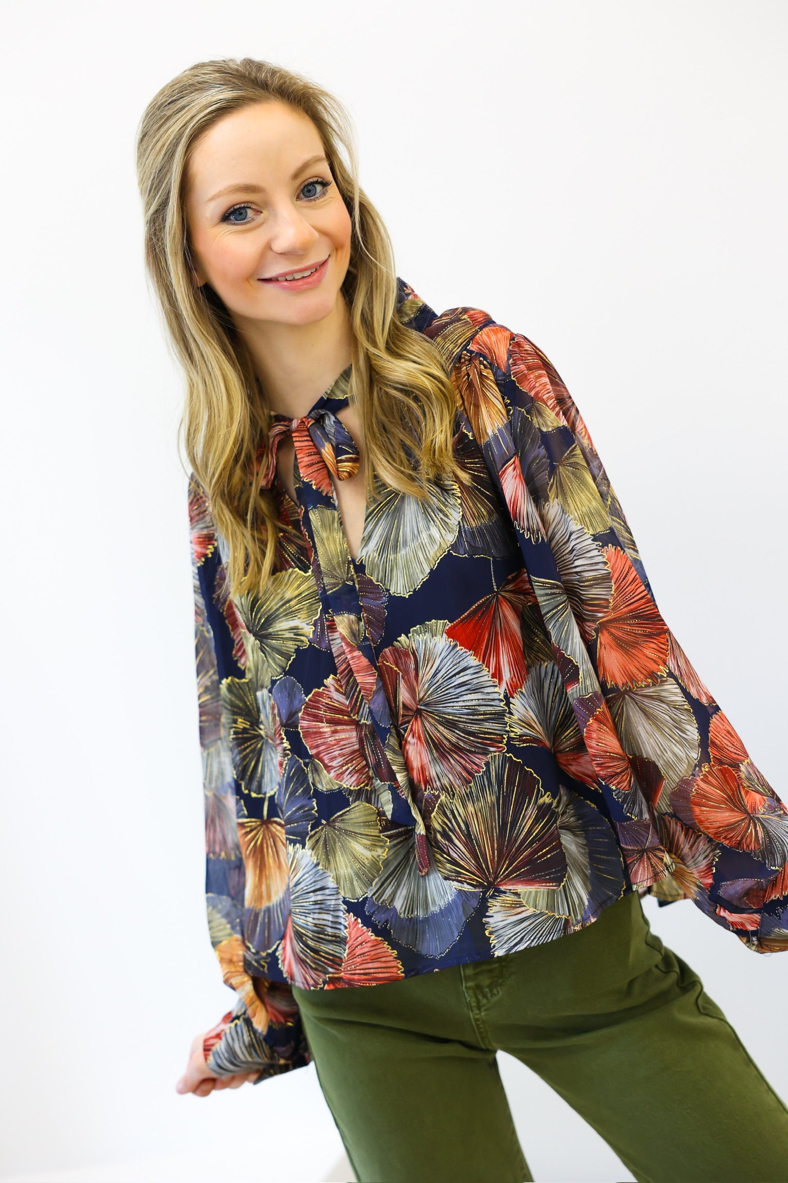 Woman wearing a colorful floral blouse with a white background