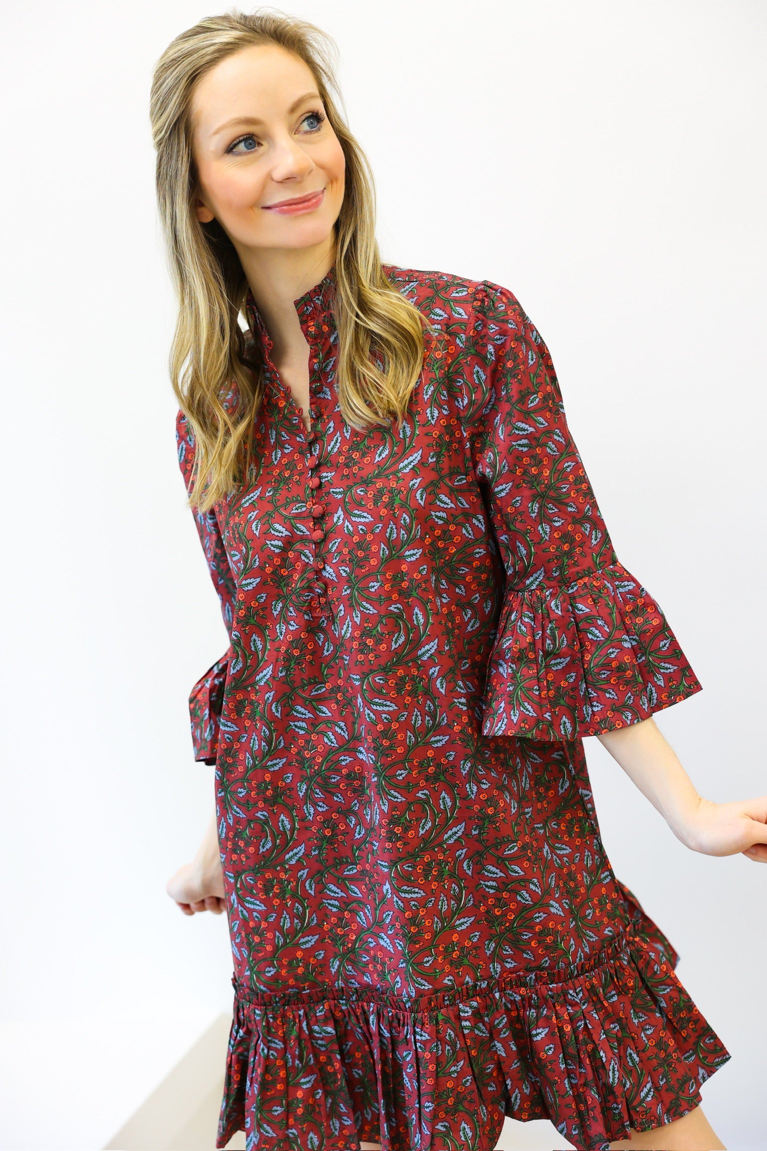 Woman wearing a red floral dress against a white background