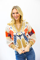 Woman wearing a colorful patterned sweater against a white background