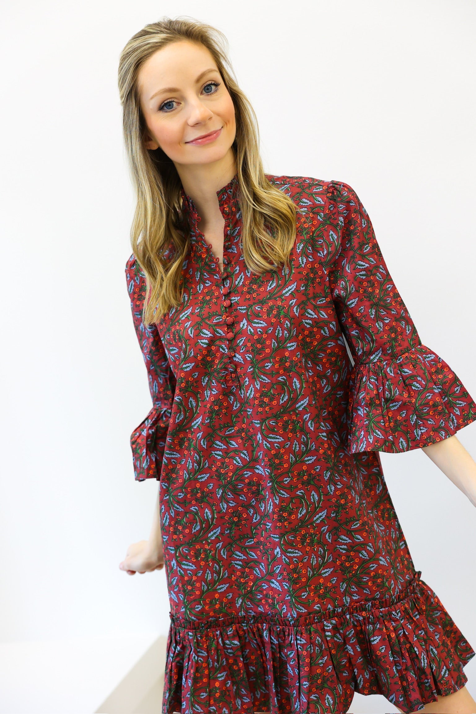 Woman wearing a red floral dress against a white background
